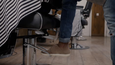 man adjusting barber chair