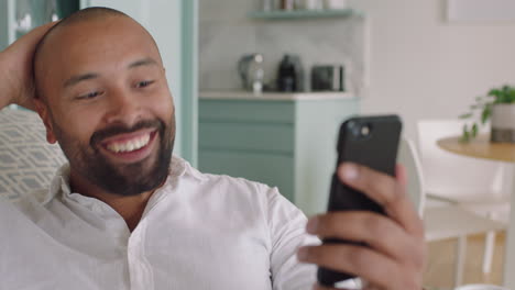 attractive young man having video chat using smartphone at home showing off hairstyle chatting sharing lifestyle enjoying online communication