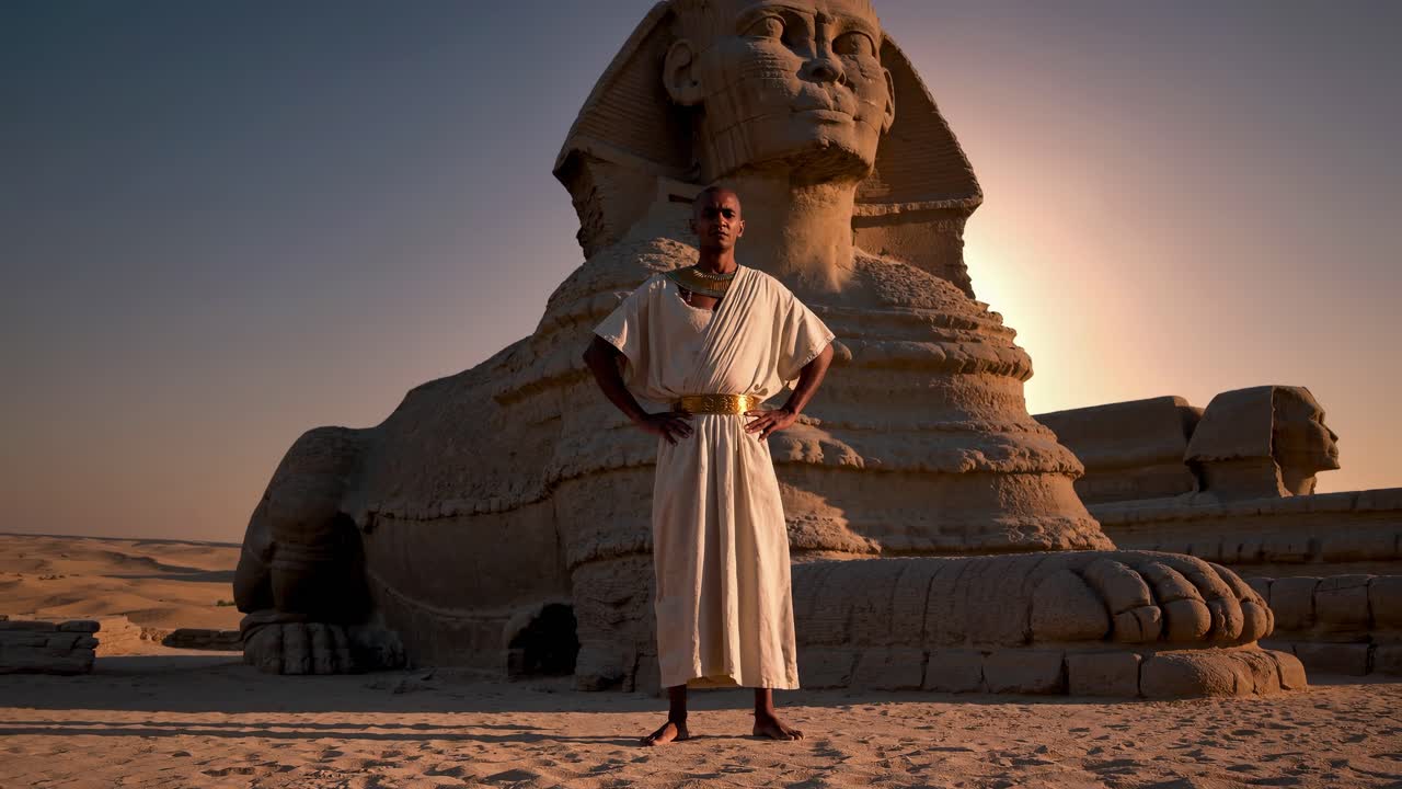 A video still shows a person in ancient attire standing confidently before the Sphinx at sunset