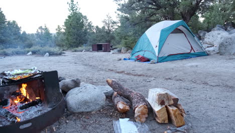 Tents-and-Campfire-at-Camp-Site-in-Afternoon,-Panning-Left-and-Right