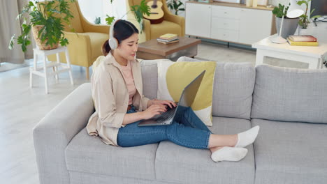 woman working on laptop from home sofa