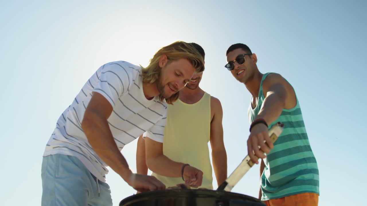 해변 4k에서 바베큐를 하는 젊은 성인 친구들