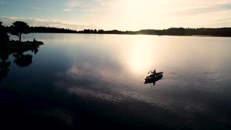 Hermoso-Amanecer-De-Colorado-En-Un-Lago-Con-Una-Silueta-De-Una-Canoa-Contra-El-Sol-Naciente