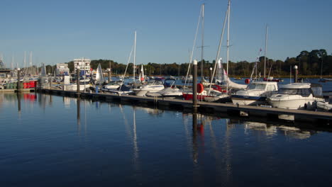 Mehrere-Segeljollen-Segeln-An-Festgemachten-Motoryachten-Vorbei-Und-Aus-Dem-Rahmen-Auf-Dem-Lymington-River