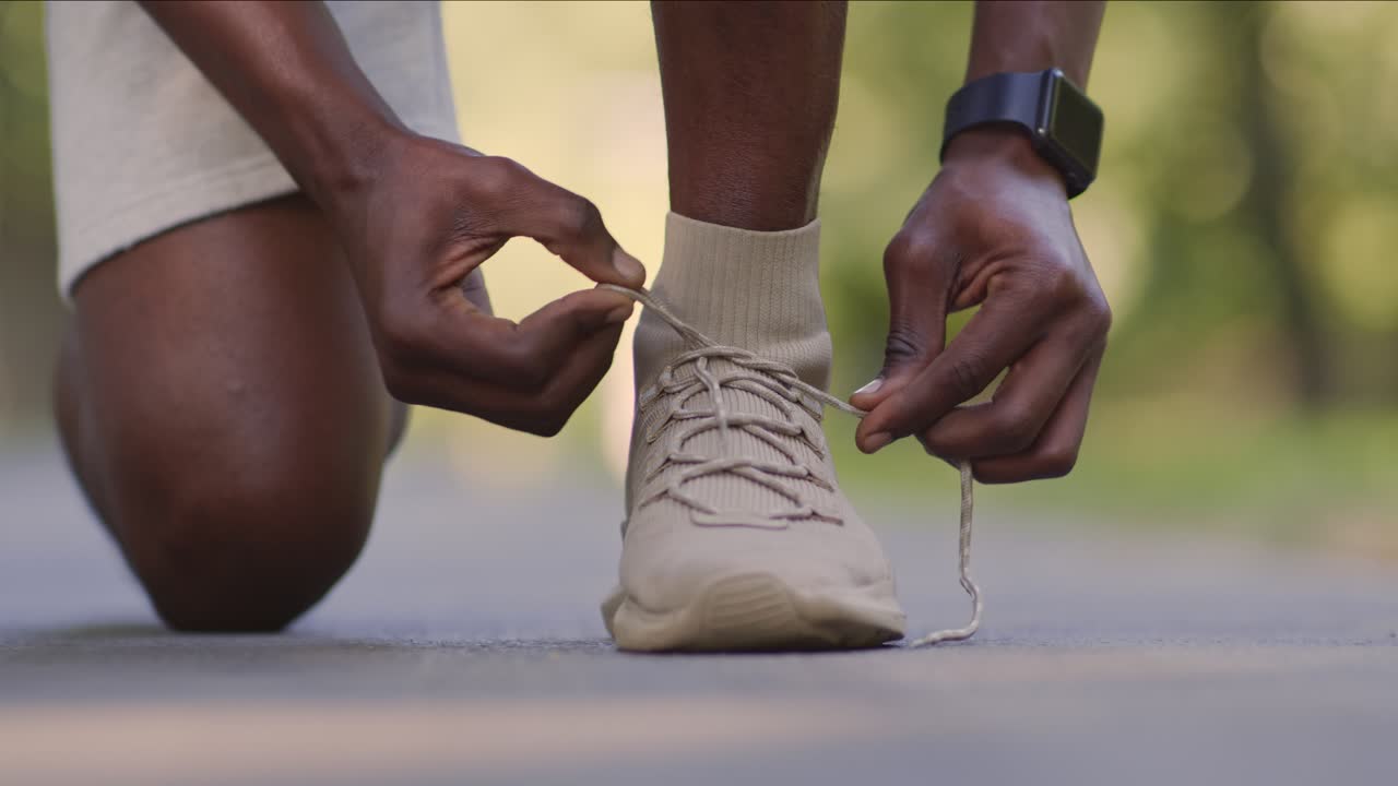 Uomo che si allaccia le scarpe da corsa.