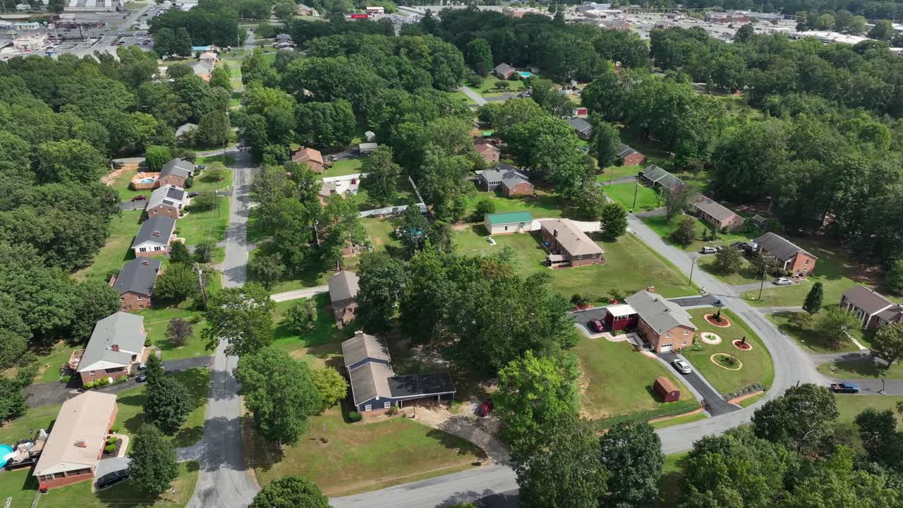 Single family houses in green suburbia of American neighborhood. Aerial flyover shot. Peaceful suburb district and classical homes. Tilt up