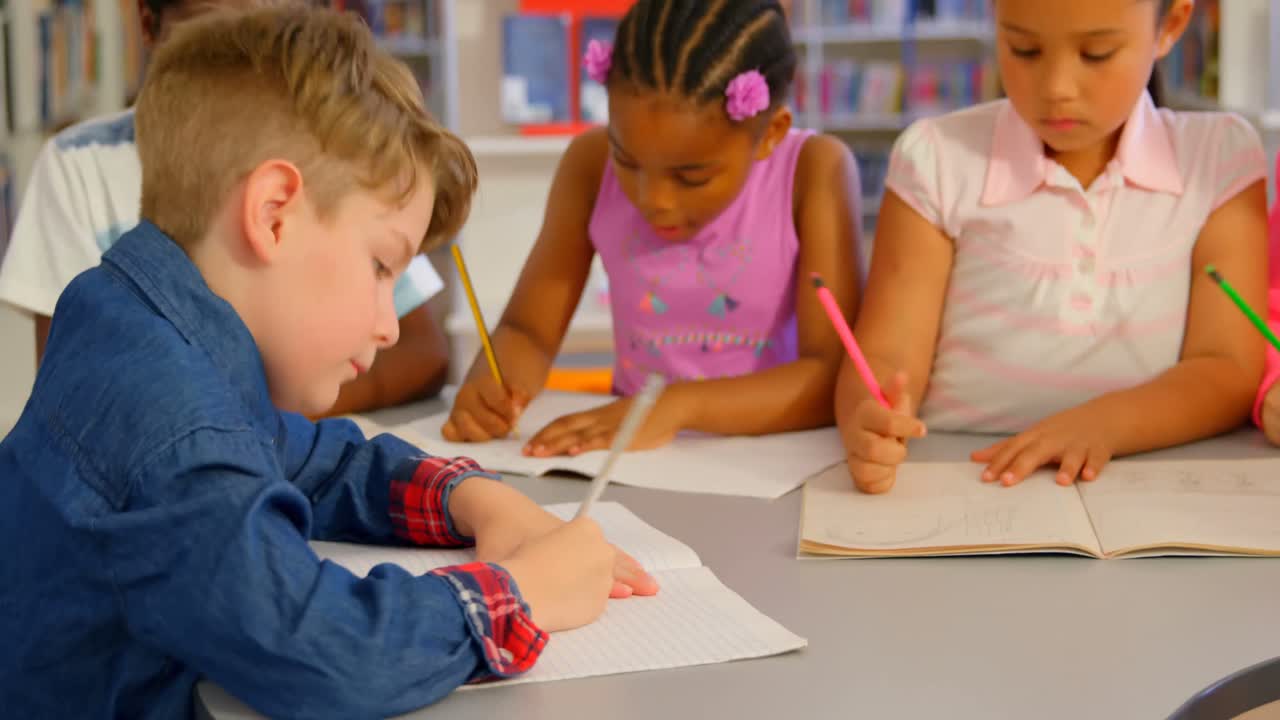 crianças estudando juntas à mesa na biblioteca da escola 4k