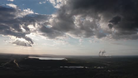 dark clouds with a coal power plant in the background