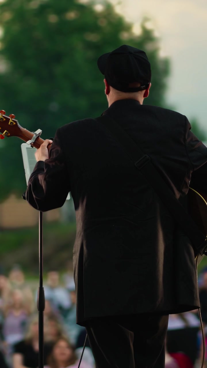 Musician Playing Acoustic Guitar and Singing on Outdoor Stage