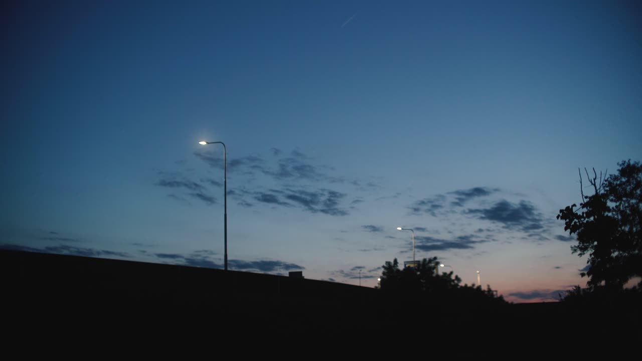 앞에서 지나가는 차와 함께 해가 지는 장면