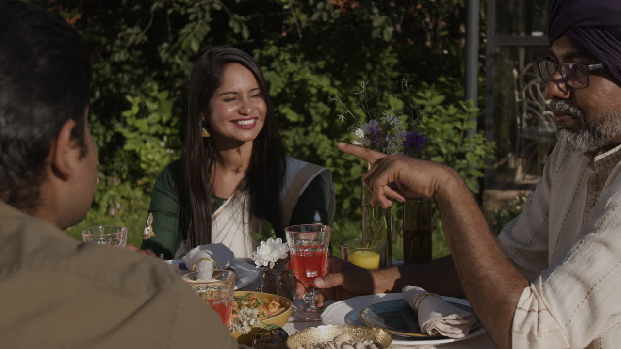Indian family enjoying an outdoor meal and conversation