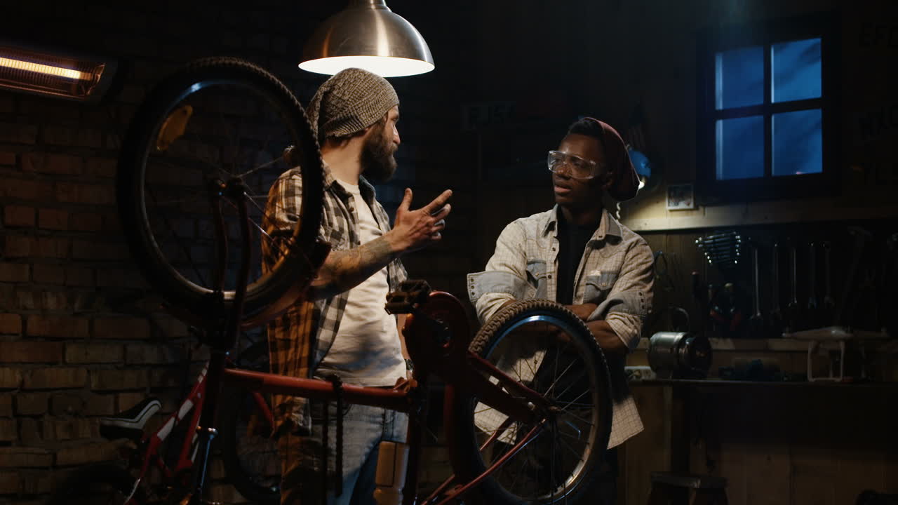 Two Men Repairing a Bicycle in a Garage at Night