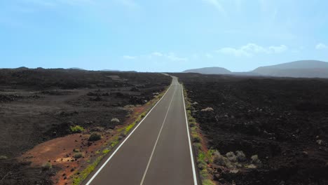 Drone-flight-over-street-Lanzarote,-Mountains