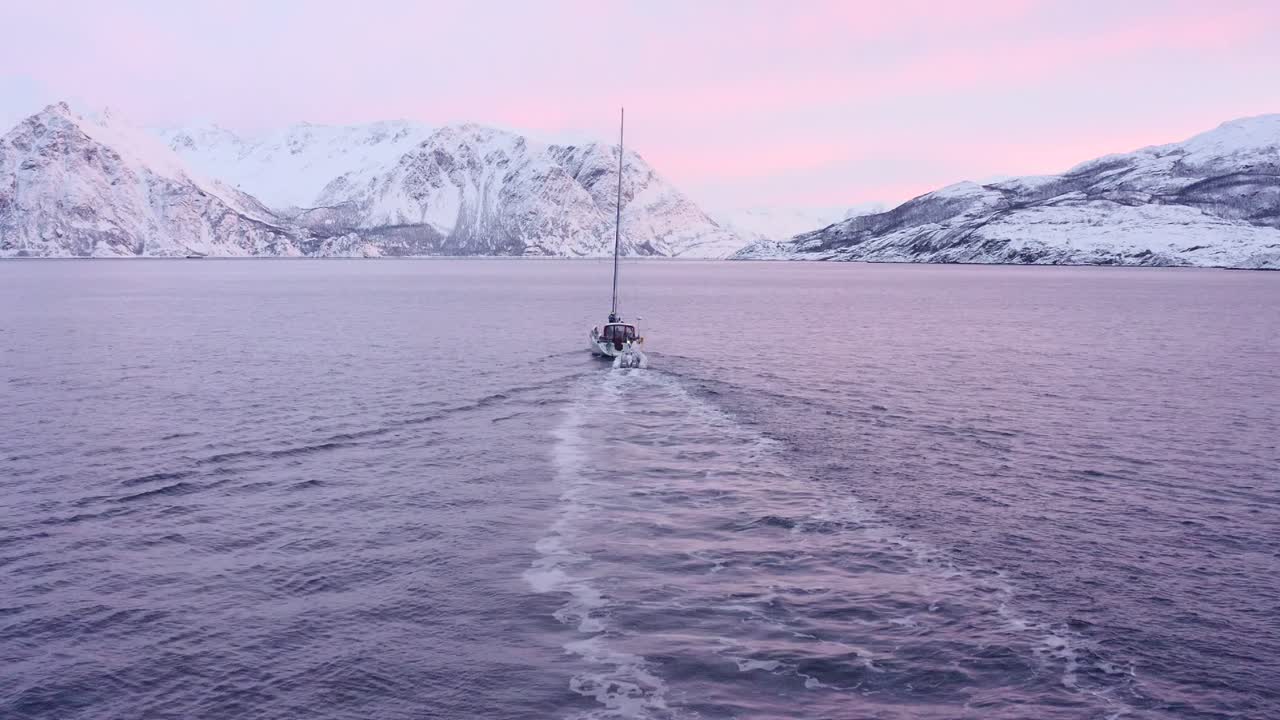 Drohnenaufnahme des violetten arktischen Leuchtens in den Fjorden im Januar.