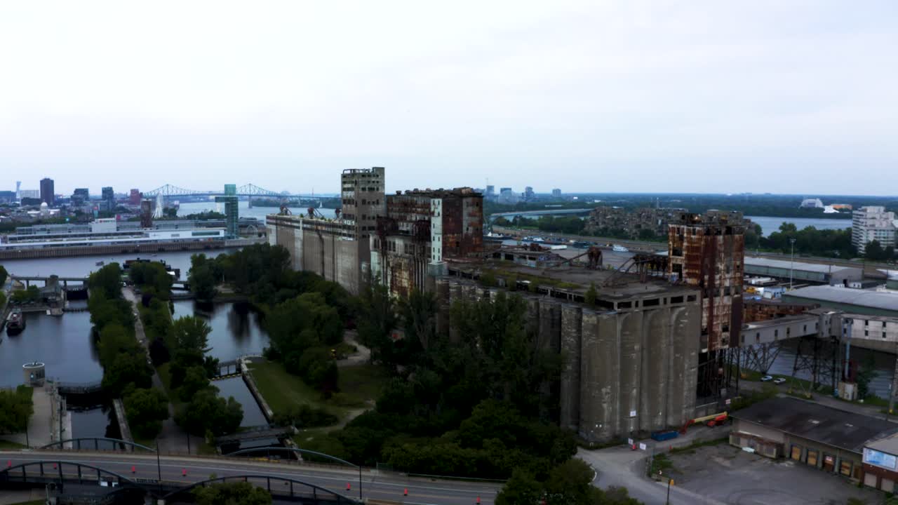 Aerial shot of an old shipping yard in Montreal, featuring rows of weathered containers and industrial cranes. Captures the raw, historical charm of the port's past operations.