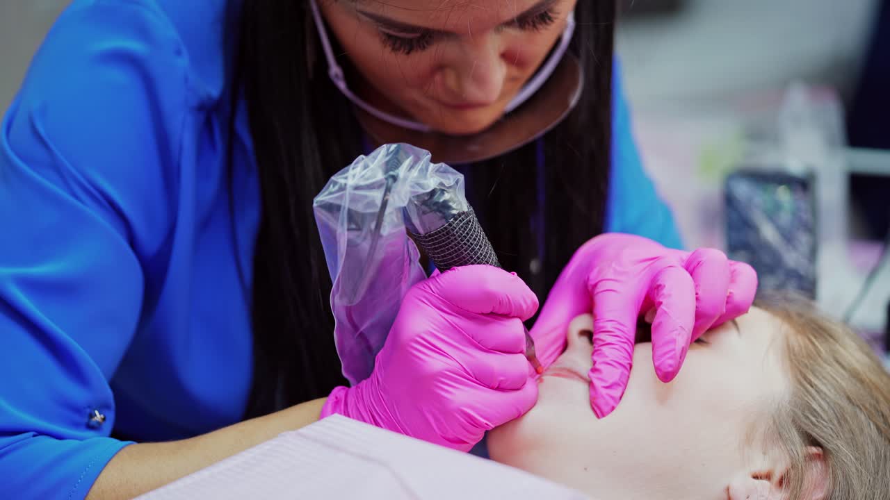 Woman making permanent makeup in salon. Young beautiful woman having permanent make up tattoo on lips