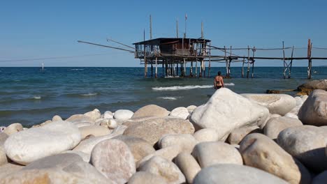 woman walks on beach of trabocchi coast. slow-motion