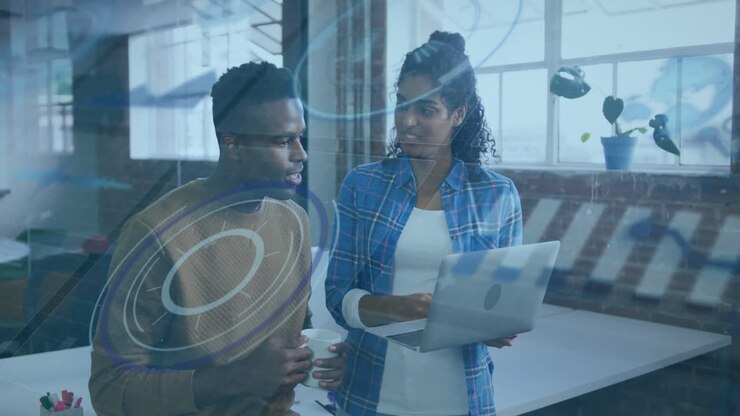 To personer diskuterer arbejde over animation af digital grænseflade på et moderne kontor.