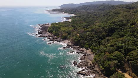 rocky stone coast with waves splashing aginst the stones dji drone shot filmed in costa rica montezuma