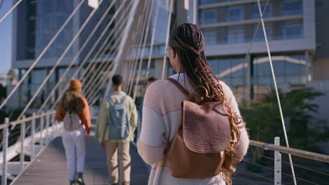 group of students walking across a modern bridge