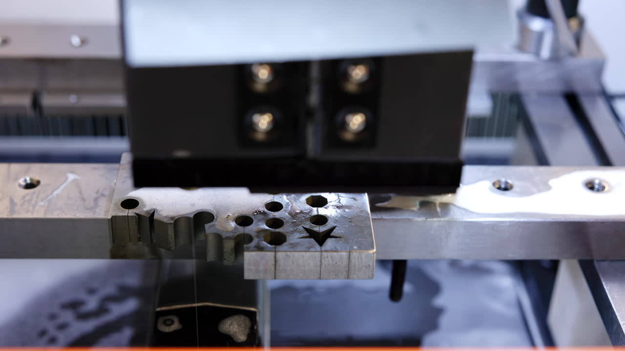 Close-up of a wire EDM machine cutting metal