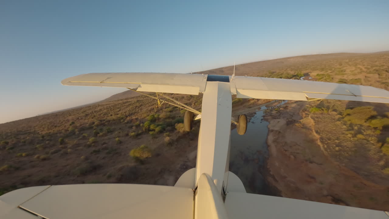 Avioneta de expedición volando sobre un río en la sabana