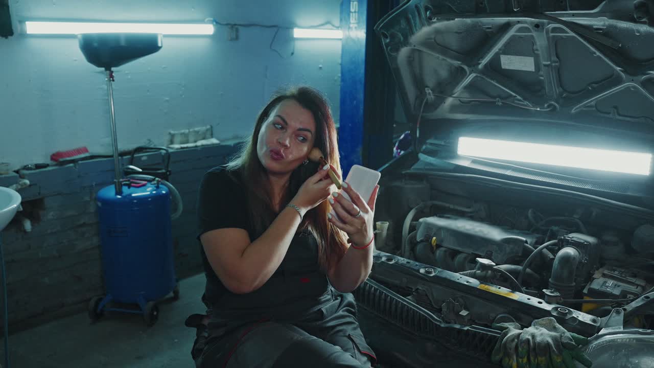 Woman Applying Makeup in a Car Repair Shop
