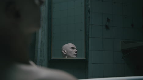 pale bald skinny man takes a bath in the creepy old bathroom at night