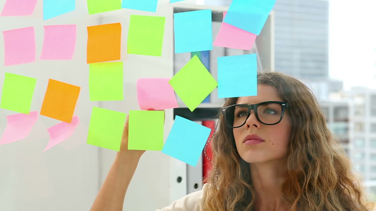 Pretty designer looking at post its on window