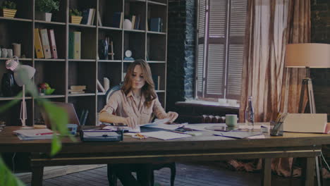 responsible businesswoman working with documents in cozy studio