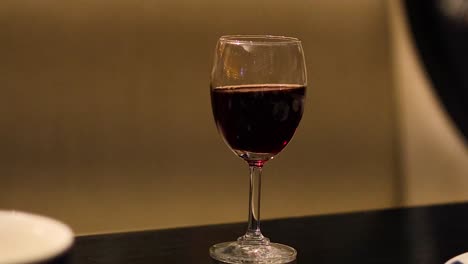 a glass of red wine on a table