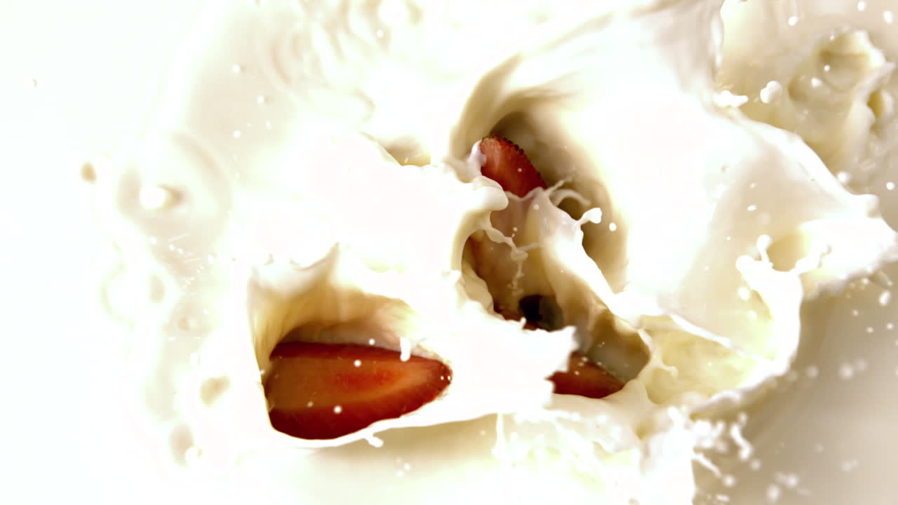 fresa cayendo en un vaso de leche