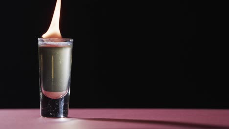 video de alcohol encendido en vidrio con llamas de fuego amarillas y espacio de copia en fondo negro