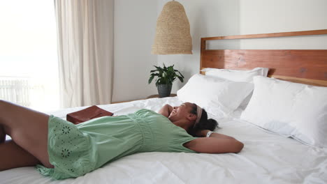 relaxing at home, woman resting on bed with handbag nearby
