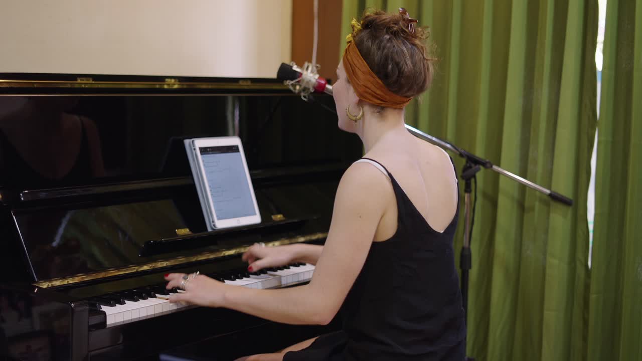 Woman Playing Piano with Tablet and Microphone