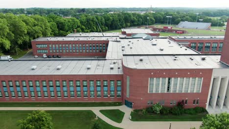 aerial truck shot of large public school building in united states, closed due to covid-19, coronavirus pandemic in usa