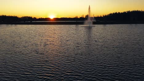 beautiful aerial shot of a water fountain with the sunset behind in land o'lakes, florida