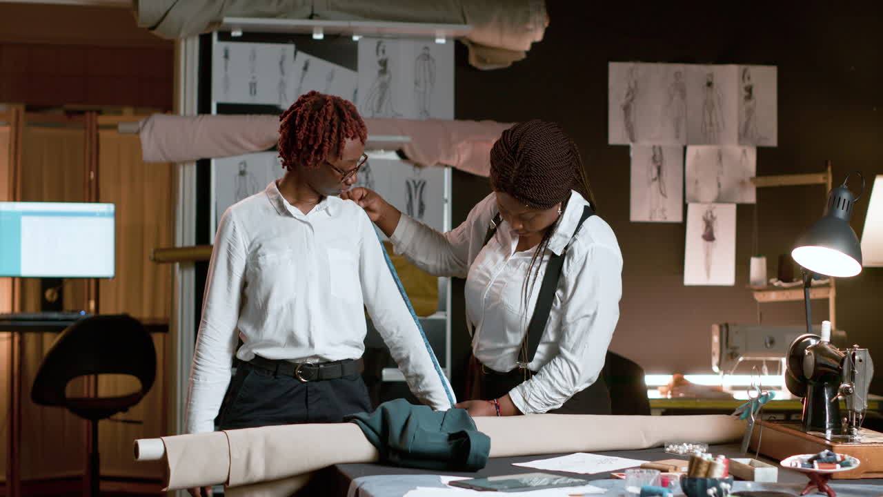 재단사를 위해 포즈를 취하는 고객