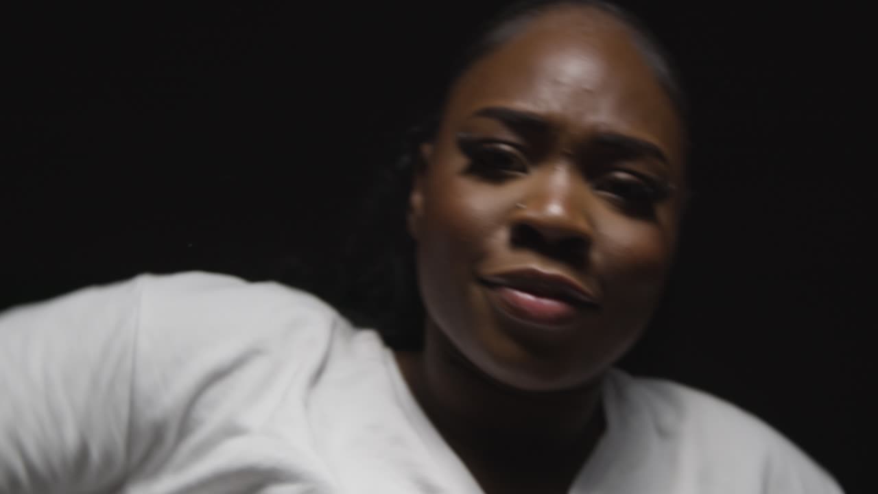 머리와 어깨 스튜디오 초상화  ⁇ 은 젊은 여자가 검은 배경에 낮은 키 조명과 함께 춤을 춘다 1