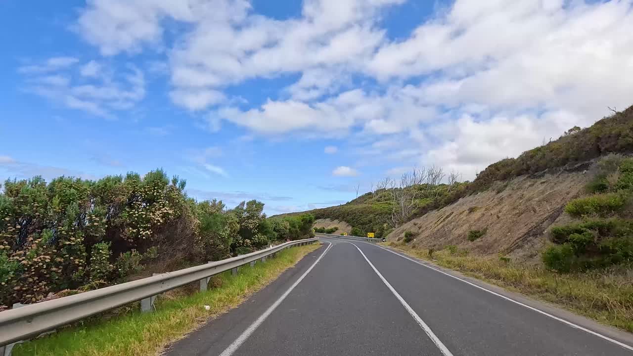 A 14-second video capturing a drive along the Great Ocean Road, showcasing lush greenery, coastal views, and winding roads under a bright sky
