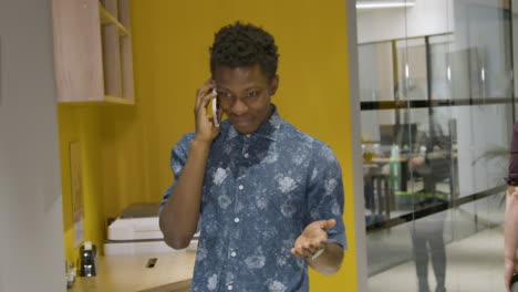 man talking on smartphone in corridor