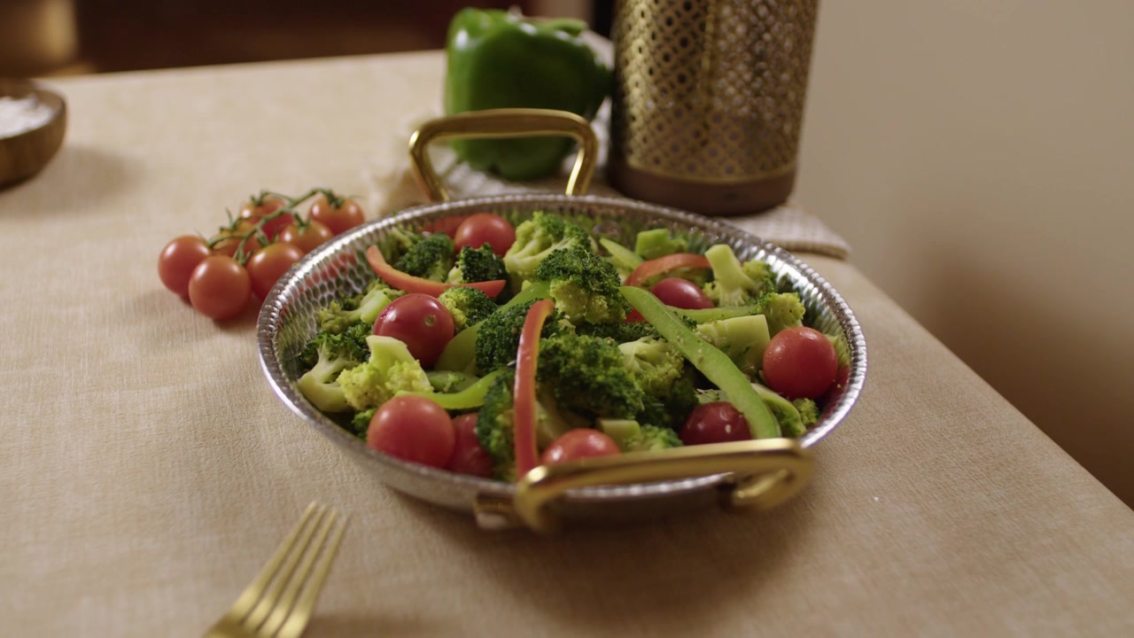 Insalata fresca di verdure con pomodori, broccoli e peperoni servita su un tavolo da pranzo