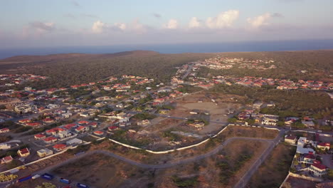 Coches-Circulando-Por-La-Carretera-En-El-Norte-De-Aruba-Con-El-Mar-Caribe-De-Fondo