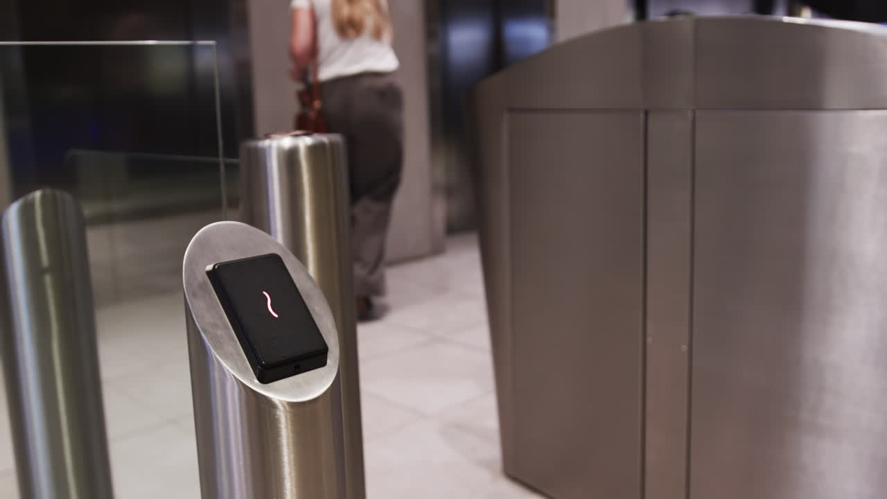 Using keycard for access, person entering office building through security gate