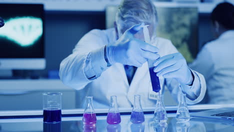 científico de laboratorio maduro usando una jeringa