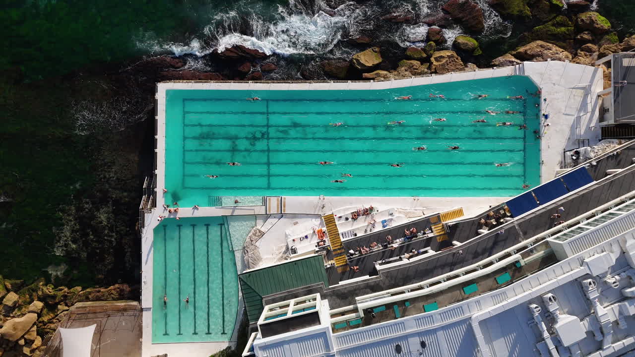 Downward angle drone shot of an ocean pool at Bondi Beach, Australia. Slowly rising aerial footage.