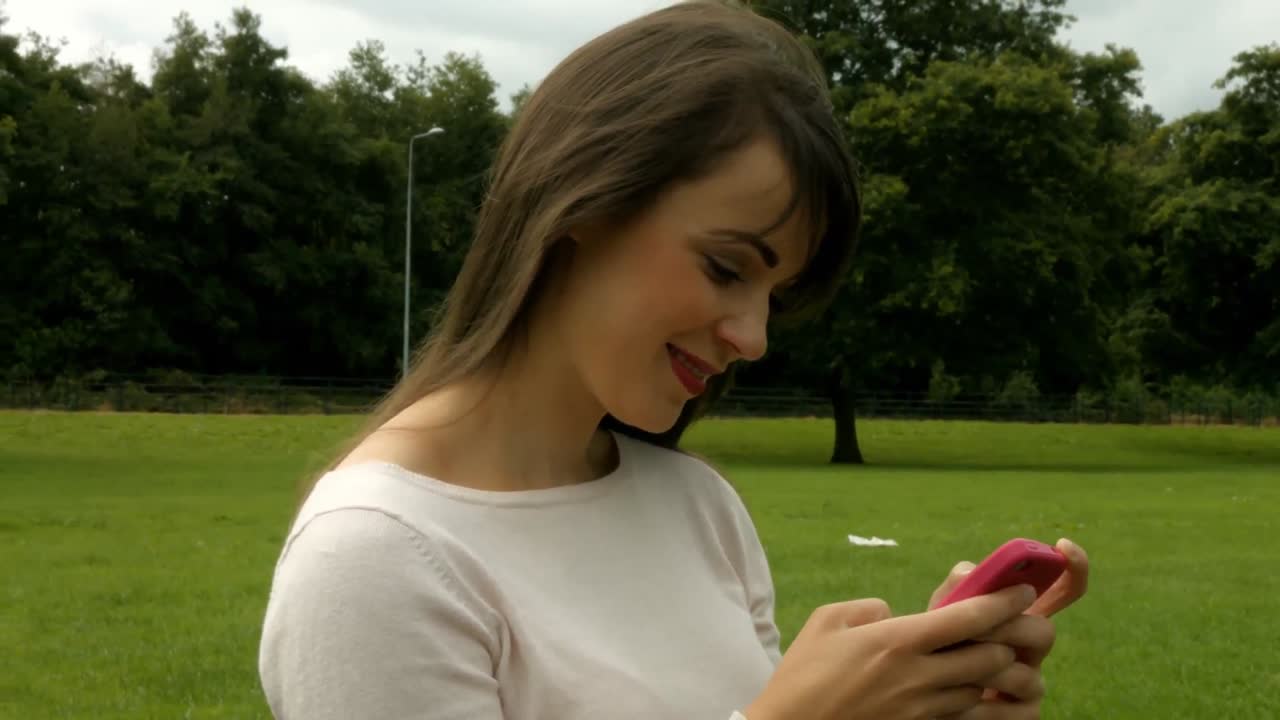 Donna graziosa che per mezzo di uno smartphone