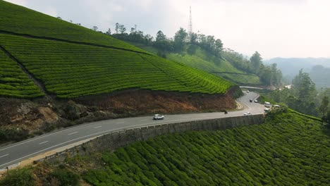 aerial drone shot of munnar’s rolling hills covered in lush green tea plantations