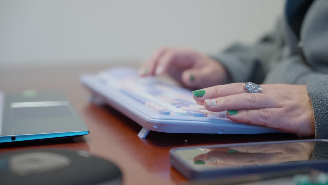 Mani femminili digitano su tastierino numerico con dispositivo digitale su una scrivania da ufficio, inserimento manuale dei dati