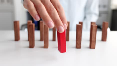 woman putting red block in front of wooden blocks on table closeup 4k movie slow motion